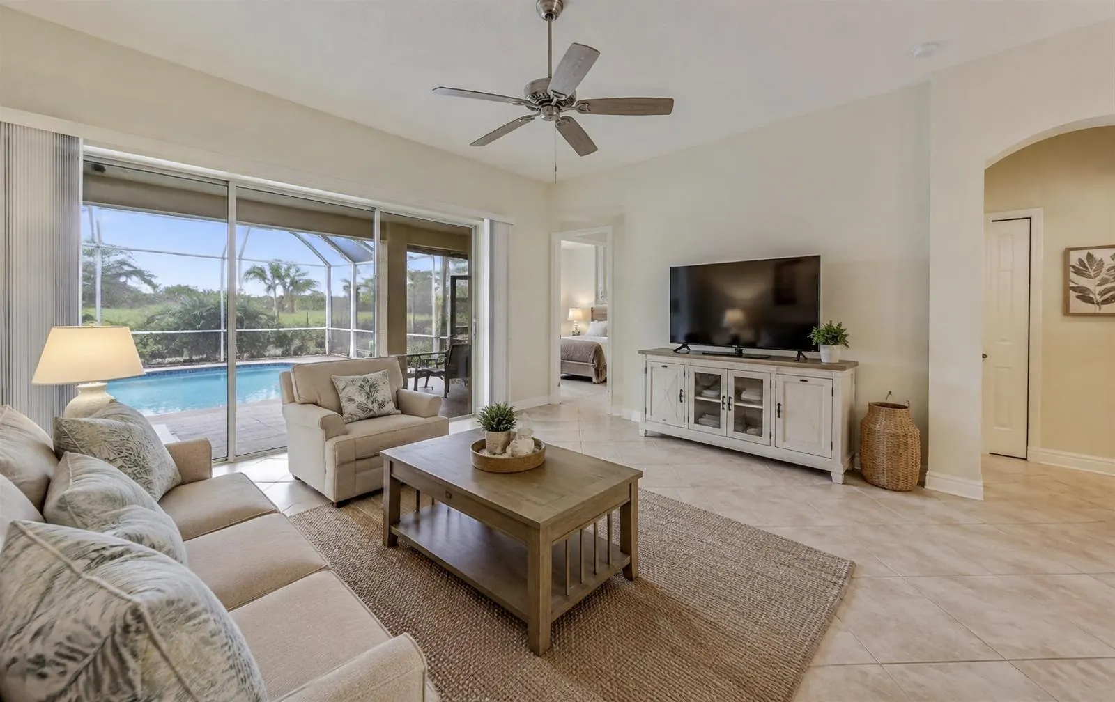 Bright Florida living room opening to a screened pool lanai